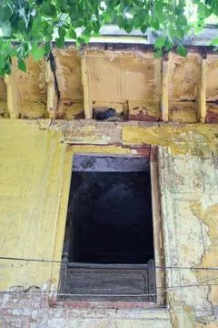 Open window in a decaying historic yellow facade Stock Photos