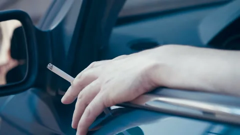 In the open window a man puts his hand in which a cigarette is smoke Stock Footage 138294718