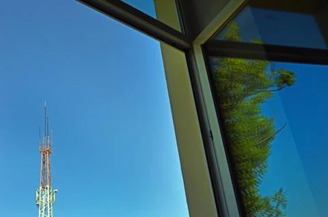 Open window overlooking the sky, tree and mobile phone antenna. Selective foc Stock Photos