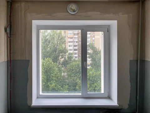 Open window in progress of repair or painting, revealing outdoor greenery a.. Stock Photos
