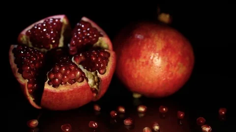 Opened and whole garnet lie on a black table Stock Footage 89962360