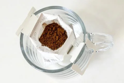 Opened bag of drip coffee in a clear cup Stock Photos