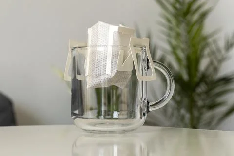 Opened bag of drip coffee in a clear cup Stock Photos