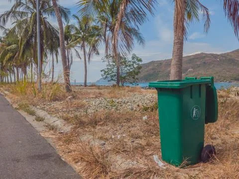 Opened big empty green plastic trash garbage bin in modern comfortable village Stock Photos