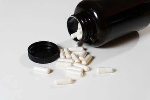 Opened black bottle with capsule white pills Stock Photos