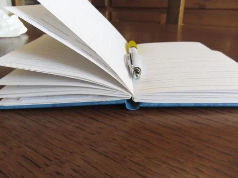 Opened blank lined notebook with pen on wooden table Stock Photos