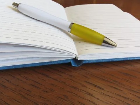 Opened blank lined notebook with pen on wooden table Stock Photos