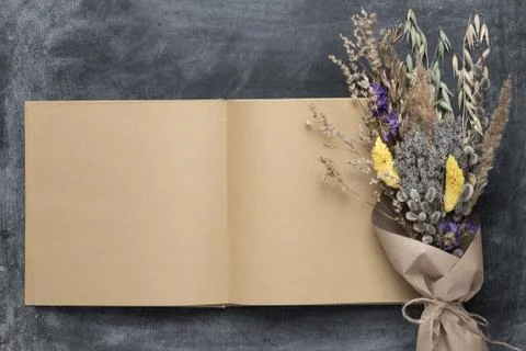 Opened blank sketchbook mockup with brown pages and spring bouquet of dried f Stock Photos