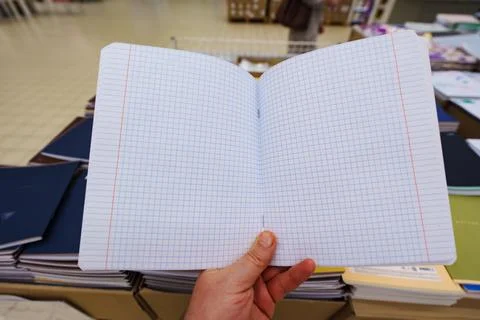 Opened blank squared notebook in hand Stock Photos