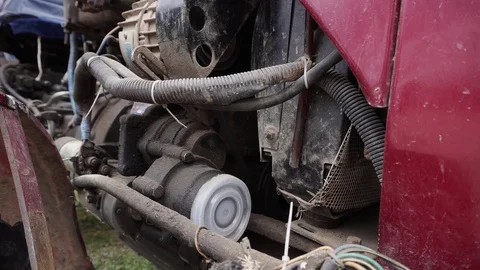 An opened bonnet of a red tractor and its old engine with many wires. Stock Footage 114326029