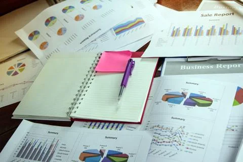 Opened book and pen put on Business paper chart plenty on wooden desk,data fo Foto stock