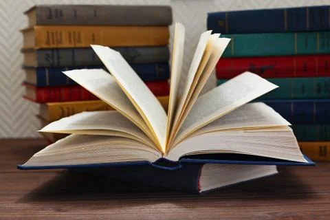 Opened book in front of stack of books Stock Photos