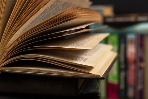 Opened book, lying on the bookshelf in library Фото