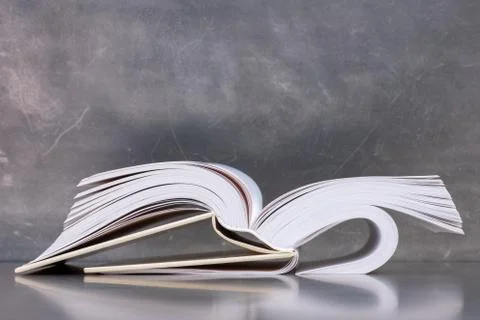 Opened book lying down against a grange background 스톡 사진