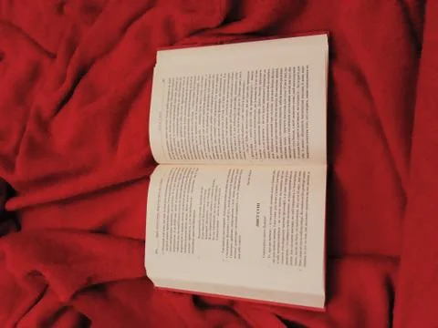 Opened book on red blanket 写真素材