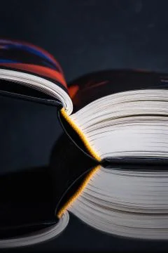 Opened book with reflection on table Stock Photos