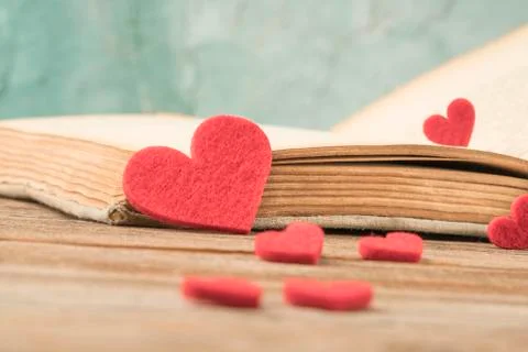 Opened book on table decorated with hearts Stock Photos