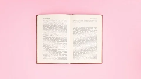 Opened books changing on pink background - Stop motion Stock Footage 129492124