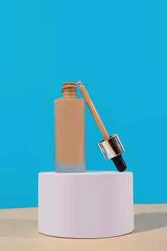 Opened Bottle with foundation liquid beige cream on stand, white podium. Pr.. Stock Photos