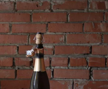 An opened bottle of sparkling wine with a cork and a muzzle on the neck of .. Foto stock