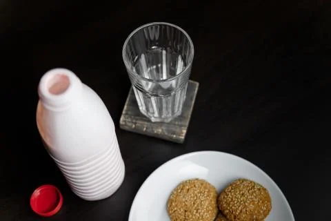 Opened bottle of strawberry or raspberry yogurt standing on black table Stock Photos