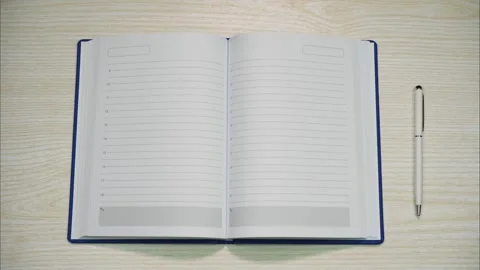 Opened business diary with pen next to it. Stop motion Stock Footage 300124842
