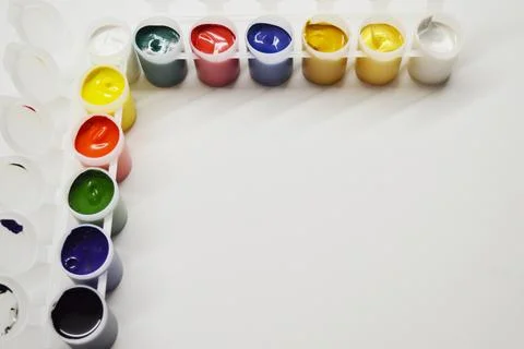 Opened cans with different paints on a white background Stock Photos