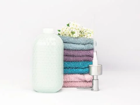 Opened ceramic soap dispenser turquoise color with multicolored soft towels Foto stock