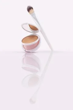Opened compact powder, blusher with makeup brushes on Glossy Surface Foto stock