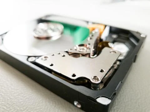Opened computer hard drive on a table prepared to be fixed. Stock Photos