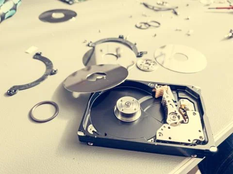 Opened computer hard drive on a table prepared to be fixed. Stock Photos