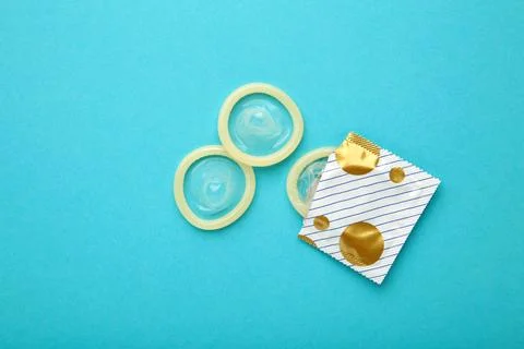 Opened condom in pack on blue background. A condom use to reduce the probab.. Stock Photos
