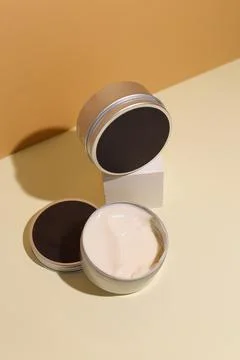 Opened container with cream on a beige background. Foto stock