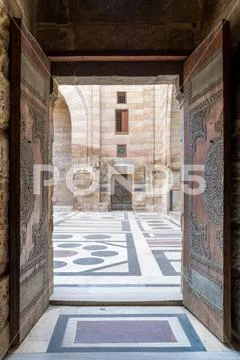 Opened door leading to the courtyard of Al-Sultan Al-Zahir Barquq mosque Stock Photos