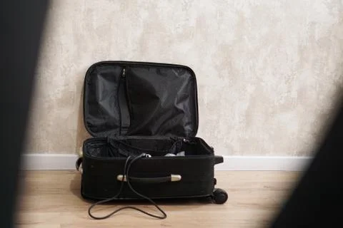 Opened empty black suitcase for different things on gray background Stock Photos
