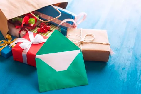 Opened envelope and bag full of gifts Stock Photos