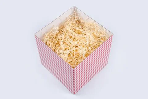 Opened gift box with decorative straw, filler, shavings. Top view, empty gift Stock Photos