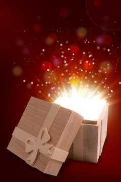 Opened gift box that emits a warm and bright light Stock Photos