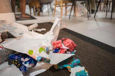 Opened gifts, torn wrapping paper and discarded packaging left on the floor.. Stock Photos