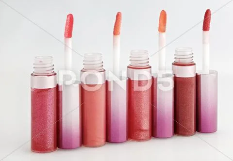 Opened gloss for lips set with color brushes on white, arranged in line persp Stock Photos