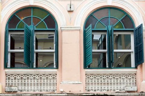 The opened green window on the yellow wall Stock Photos