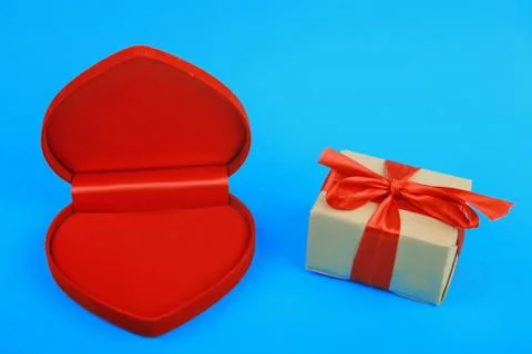 Opened heart shaped box and present wrapped with red ribbon Foto stock