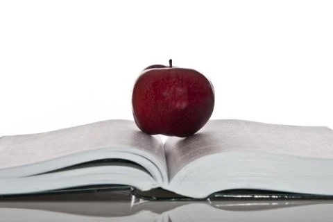 Opened hefty book and fresh red apple Stock-Fotos