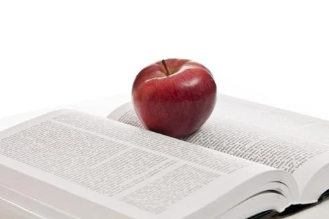 Opened hefty book and fresh red apple Stock Photos