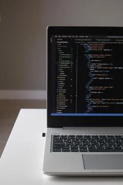 Opened laptop with code on the screen on the table 스톡 사진