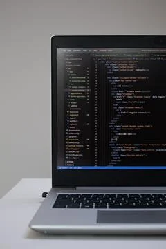 Opened laptop with code on the screen on the table 스톡 사진