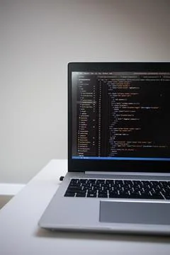 Opened laptop with code on the screen on the table Foto stock