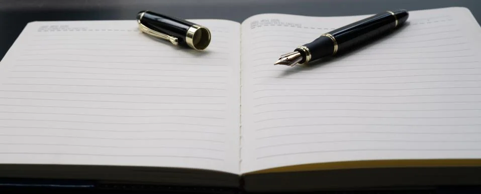 Opened lined diary notebook with a luxury pen with copy space Stock Photos