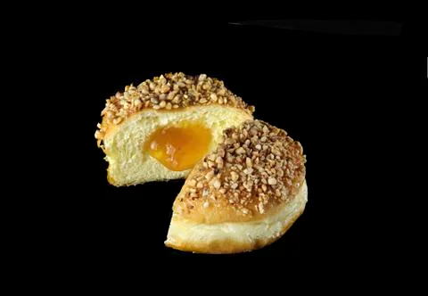 Opened marmellade doughnut on black background with nuts Stock Photos