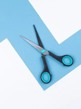 Opened  metal scissors over turquoise blue background. Foto stock